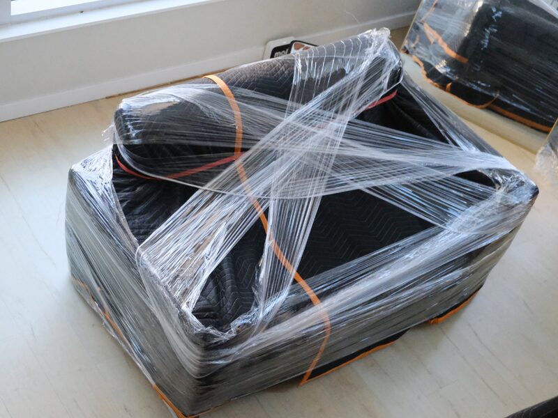 Couch fully wrapped in blankets and straps ready for transport